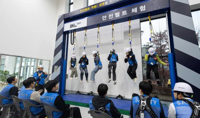  DL이앤씨 신입사원들이 대전 대덕연구단지에 위치한 안전체험학교에서 안전벨트 사용법을 실습하고 있다사진DL이앤씨