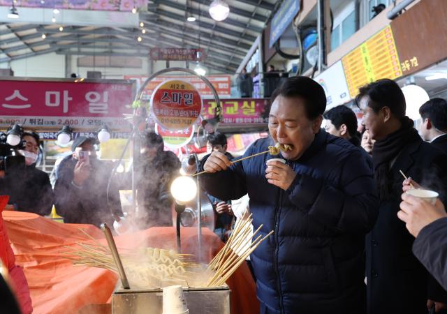 윤석열 대통령이 25일 경기도 의정부시 의정부제일시장을 찾아 어묵을 먹고 있다 사진연합뉴스