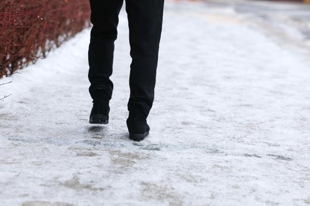 지난 18일 오전 서울 종로구에서 한 시민이 얼어붙은 오르막길을 힘겹게 오르고 있다 사진연합뉴스