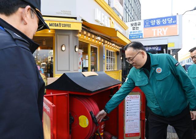 이한경 행정안전부 재난안전관리본부장이 26일 광주시 양동시장을 찾아 소화기함을 점검하고 있다 사진행안부