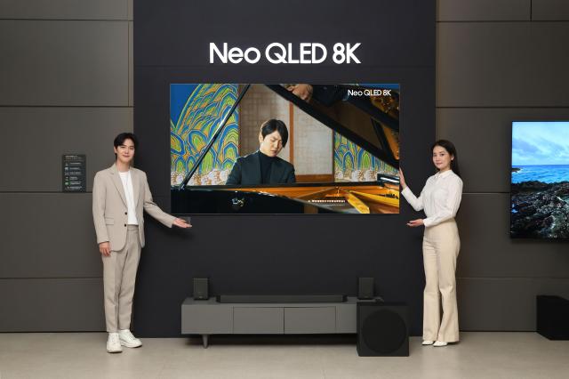 삼성전자 모델이 삼성스토어 대치점에서 Neo QLED 8K TV로 파이니스트 조성진의 8K 라이브 연주 영상을 감상하고 있다