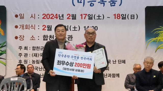 제5회 한국춘란무명품전국대회에서 홍화소심으로 대상을 차지한 울산 김호진씨가 김윤철 합천군수왼쪽과 수상 후 기념촬영 하고 있다사진합천군 