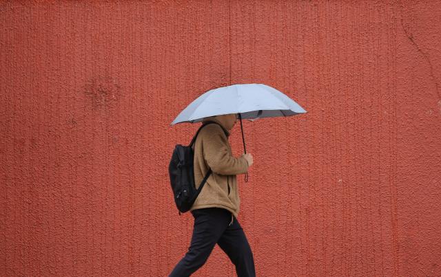 21일 오전 서울시의회 본관 인근에서 우산을 쓴 시민이 이동하고 있다 사진연합뉴스