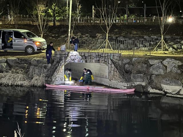 하남시청 직원들이 25일 유류가 흘러 들어가 오염된 망월천에서 흡착붐과 흡착포 등을 설치하는 방제작업을 통해 오염 확산을 막고 있는 모습 사진하남시