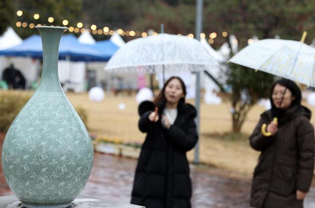 제52회 강진 청자축제 기간 중 비가 내리는 가운데 관광객들이 청자에 심취해있다강진김옥현 기자