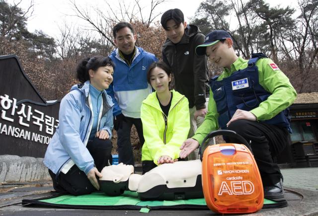 에스원 임직원이 공원 관계자에게 AED 사용법을 안내하고 있다 사진에스원