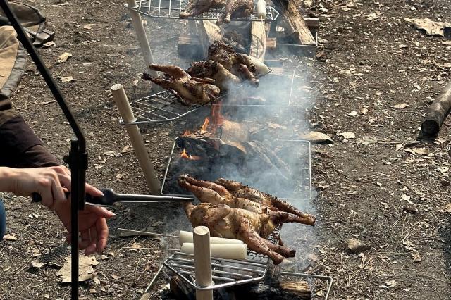 장작 위에 그릴을 얹어 닭을 굽는다 사진김다이 기자