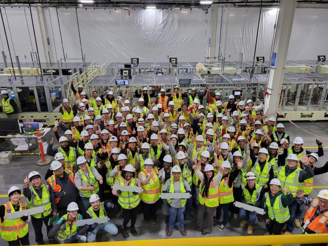 얼티엄셀즈 직원들이 제2공장에서 생산된 첫 배터리를 들고 기념사진을 찍고 있다 사진LG에너지솔루션