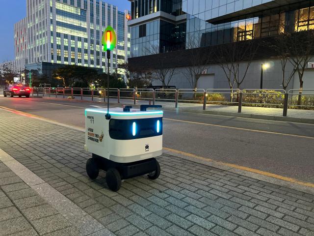 The outdoor version of Gaemi a service robot developed by South Korean robotics company ROBOTIS is moving along a street in southwestern Seoul to deliver food and drinks to customers homes Courtesy of ROBOTIS
