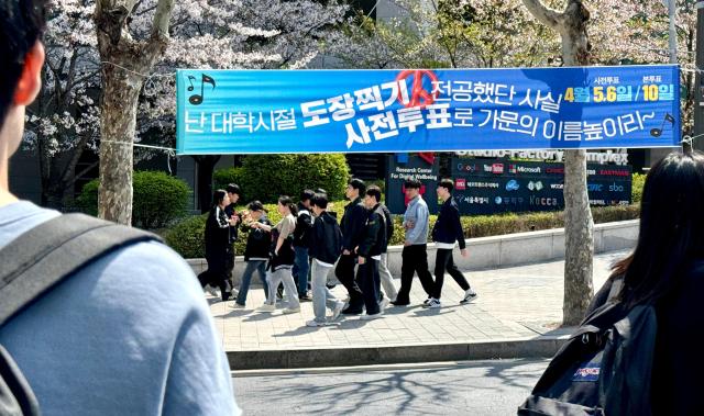 People walk past a banner encouraging students to vote on the eve of the April 10 general elections near the campus of Chung-Ang University Dongjak-gu Seoul April 9 2024 AJU PRESS Kim Dong-woo