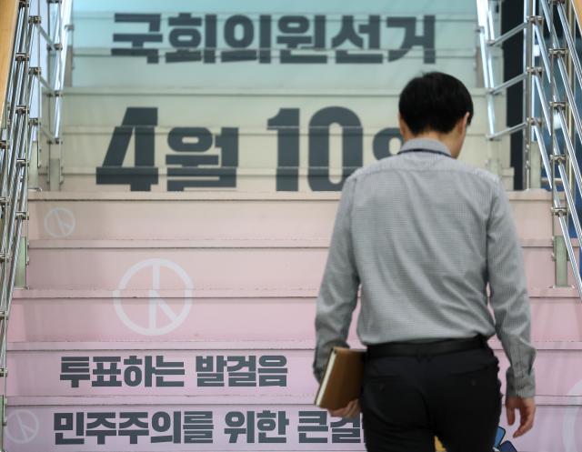 A man walks up the stairs decorated with election phrases at the National Election Commission building in Gwacheon Gyeongi Province April 9 2024 Yonhap