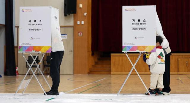 22대 국회의원 선거일인 10일 부모와 함께 대전 한 투표소를 찾은 아이들이 기표소 안에 들어가 투표하는 방법을 보고 있다 사진연합뉴스