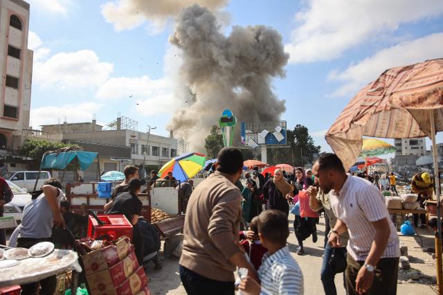 팔레스타인 사람들이 4월 11일현지시간 가자시티의 한 마켓에서 이스라엘 폭격으로 연기가 피어오르는 모습을 보고 있다 사진AFP 연합뉴스