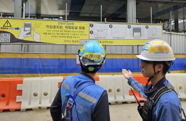 경기도에 위치한 한 건축현장에서 근로자들이 작업중지권 현수막을 확인하고 있다 사진삼성물산
