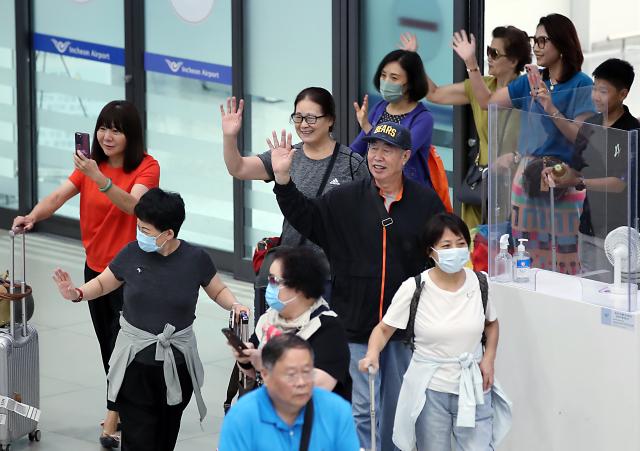 중국인 단체 관광객들이 인천국제공항을 통해 입국하며 손을 흔들어 인사하고 있다 사진공동취재
 