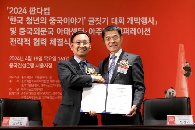 Yang Gyu-hyeonL Aju Daily president Chen Wenge from China International Communications Group shake hands after signing a strategic cooperative agreement at China Construction Banks Seoul branch Thursday AJU PRESS Kim Dong-woo