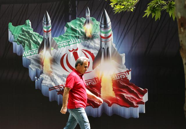 19일한국시간 이란 테헤란에서 한 남성이 이란 지도에 미사일 사진이 그려진 거대한 반이스라엘 배너 앞을 지나가고 있다 사진EPA·연합뉴스