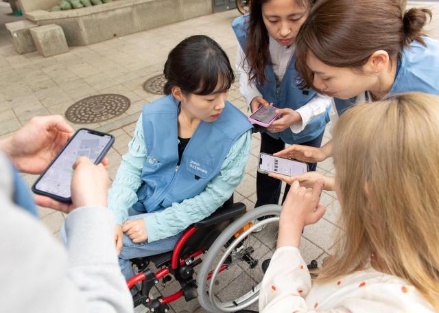 포스코인터내셔널 임직원들이 휠체어를 타고 다니며 휠체어 사용자 입장을 직접 경험하고 휠비 앱에 들어갈 위치 정보를 수집하고 있다 사진포스코인터내셔널