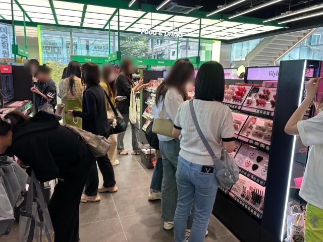 올리브영 홍대타운점 2층 색조 화장품 코너에서 제품을 구경하고 있는 손님들의 모습 사진김다인 기자