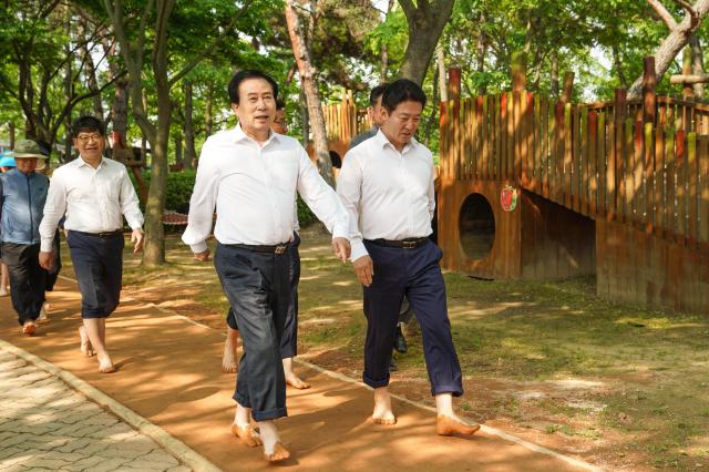박홍률 목포시장과 전경선 도의원등이 황토 맨발길을 걸으면서 건강과 치유의 시간을 함께하고 있다사진목포시