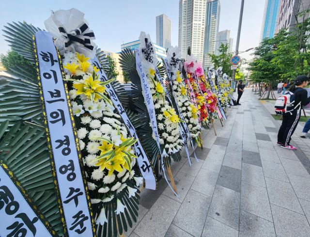 Condolence weaths are laid by BTS fans in front of the HYBE building in Seoul May 3 2024 Yonhap