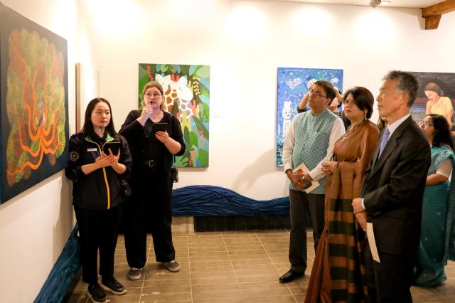 Visitors look at paintings at an exhibition on Nami Island in Chuncheon Gangwon Province May 3 2024 AJU PRESS Kim Dong-woo