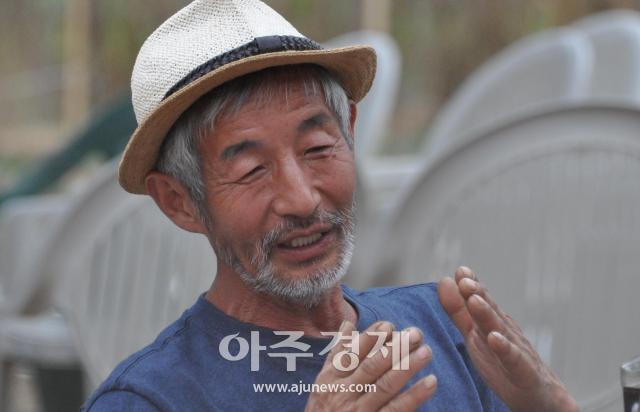 길종갑 화가가 지난 4일 회갑 기념 개인전이 열린 비닐하우스 갤러리에서 관람객들과 대화하고 있다사진박종석 기자