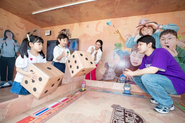 KT가 서울시와 제휴해 광화문광장 육조마당에 미디어 포털을 체험할 수 있는 지니 TV 팝업을 개최하고 참여하는 시민들에게 ENA 채널의 지구마불 세계여행2 콘텐츠를 게임으로 소개하는 모습