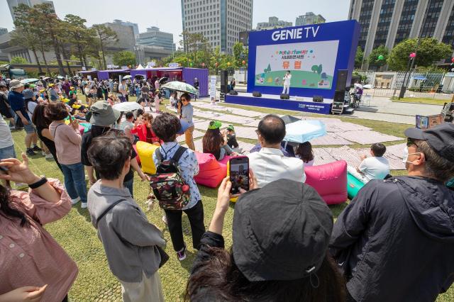 서울 시민들이 광화문광장 육조마당에 개최된 지니 TV 팝업에서 시네마 콘서트를 즐기는 모습 