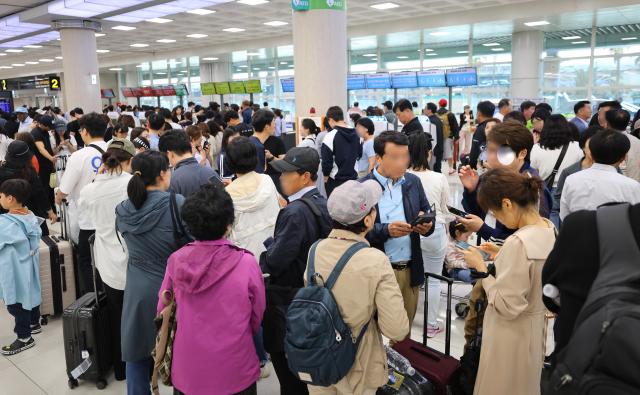 어린이날인 5일 제주국제공항에서 급변풍 등 기상 악화로 항공편 결항이 속출한 가운데 항공사 카운터 앞이 표를 구하려는 여행객 등으로 붐비고 있다 사진연합뉴스