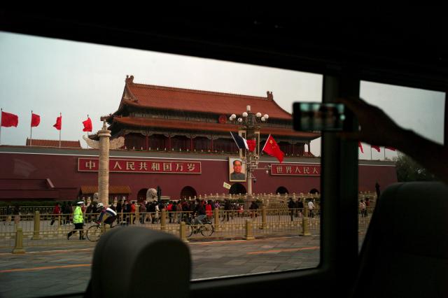 버스에 탑승한 한 여행객이 6일 중국 베이징에서 천안문에 걸려 있는 마오쩌둥의 초상화를 촬영 중이다 사진AP·연합뉴스