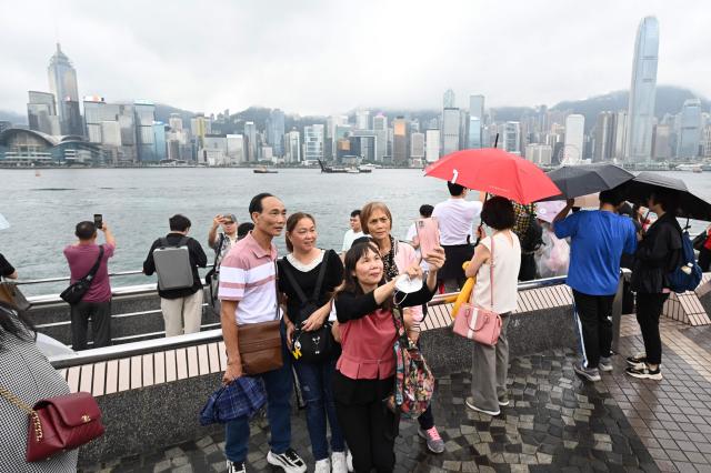 중국 노동절 연휴 첫날인 1일 홍콩을 찾은 본토 관광객이 침사추이에서 기념사진을 촬영하고 있다 사진AFP연합뉴스 