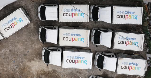 Coupang delivery trucks line up at a parking lot in Seoul on April 12 to load groceries Yonhap Photo
