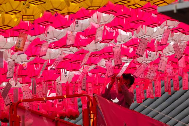 A worker hangs lotus lanterns at Jogyesa a week before the Buddhas Birthday celebrations in Jongno Seoul on May 8 2024 AJU PRESS Park Jong-hyeok
