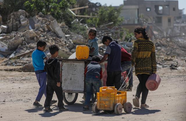 팔레스타인 피란민 아동들이 8일현지시간 가지구 남부 칸유니스에서 몰통을 채우기 위해 걸어가고 있다 사진EPA 연합뉴스