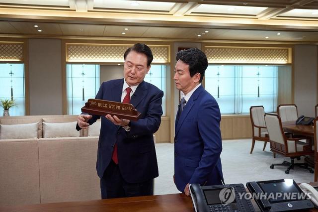 President Yoon Suk Yeol shows a plaque he received as a gift from US President Joe Biden during an interview with KBS in February Yonhap
