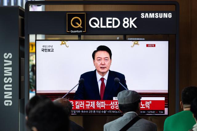 Citizens at Seoul Station watch President Yoon Suk-yeol speak during a news conference held at the presidential office in Seoul on May 9 2024 YONHAP-AJU PRESS