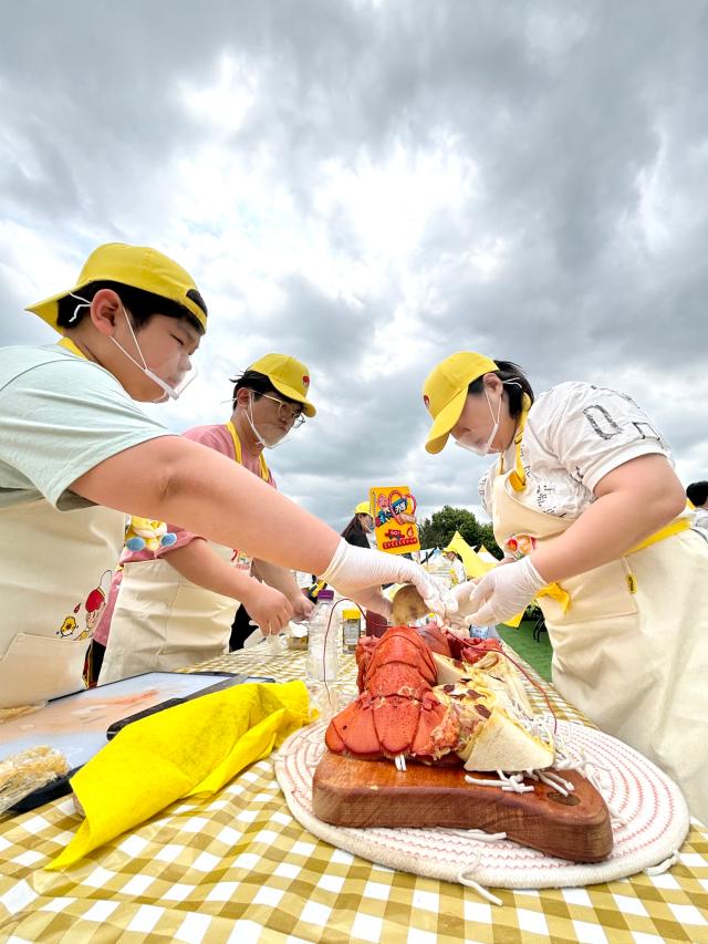 A family cooks a lobster dish at the festival AJU PRESS Han Jun-gu
