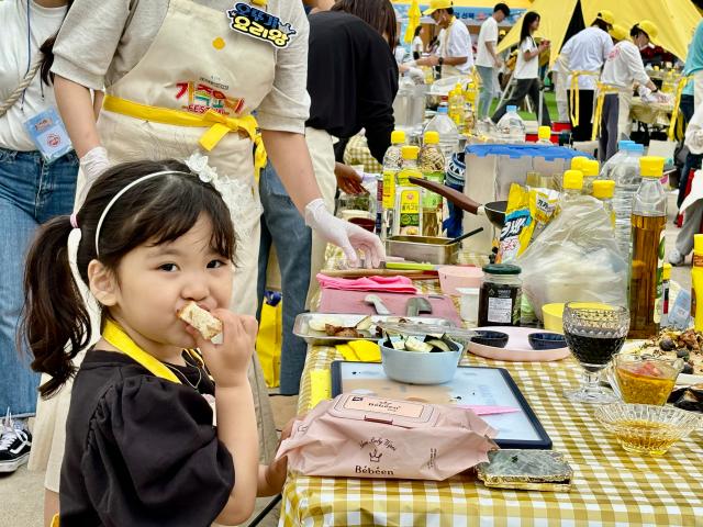 A child eats bread at the festival AJU PRESS Han Jun-gu