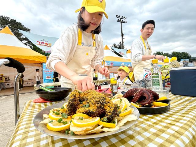 A family makes chicken and octopus dishes at the festival AJU PRESS Han Jun-gu