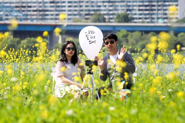 A couple takes a photo during the Rapeseed Flower Festival AJU PRESS Kim Dong-woo 