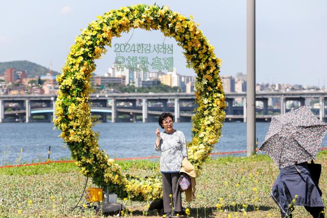 Visitors take a picture at the photo zone of the Rapeseed Flower Festival AJU PRESS Kim Dong-woo