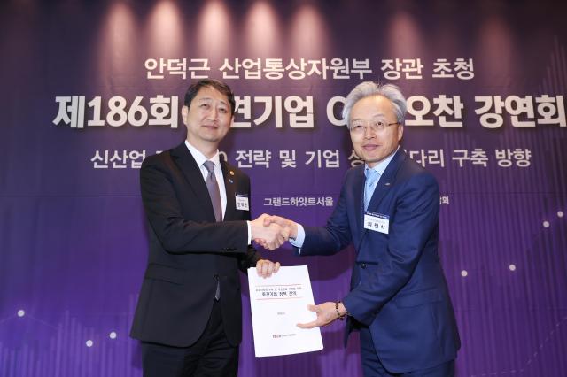 Minister Duk-geun Ahn of the Ministry of Trade Industry and Energy is shaking hands with Choi Jin-sik Chairman of the Federation of Middle Market Enterprises of Korea holding a document of policy suggestions for midsize enterprises Courtesy of FOMEK