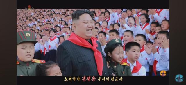 North Koreas leader Kim Jong-un smiles at the music video for  Friendly Father the countrys new propaganda song The picture was captured from YouTube