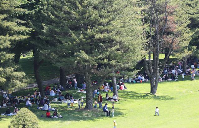 지난 13일 오전 경기도 군포시 안양컨트리클럽에서 열린 시민 무료 개방 행사를 찾은 시민들이 나무 그늘에 앉아 휴식하고 있다 사진연합뉴스