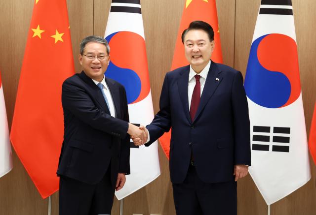 President Yoon Suk Yeol and Chinese Premier Li Qiang shake hands during their meeting at the Presidential Office in Yongsan Seoul on May 26 Joint Press Corps
