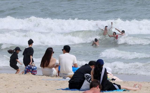 Couples enjoy warmer weather on Haeundae Beach in Busan on May 6 2024 Yonhap
