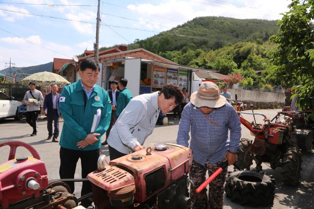 안병구 밀양시장이 지난 28일 상동 매화마을에서 열린 농기계 순회수리 교육 현장에서 고장 난 농기계를 살펴보고 농민들의 고충 사항을 듣고 있다사진밀양시