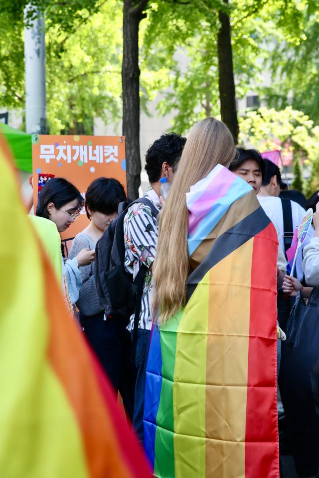 A participant drapes a rainbow pride flag at the 2024 Seoul Queer Culture Festival in the central Seoul area on June 1 AJU PRESS Han Jun-gu