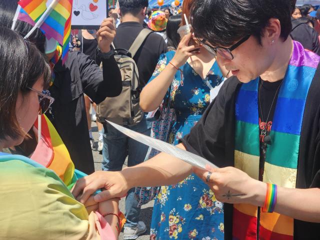 Pastor Lee Dong-hwan blesses couples visiting the Seoul Queer Festival held in central Seoul on Saturday AJU PRESS Park Sae-jin